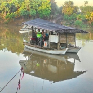 Petugas antar surat suara pakai perahu.