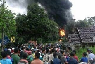 Warga berkerumun menyaksikan truk tangki yang jatuh dan terbakar di Cigudeg, Kab Bogor, tadi pagi.