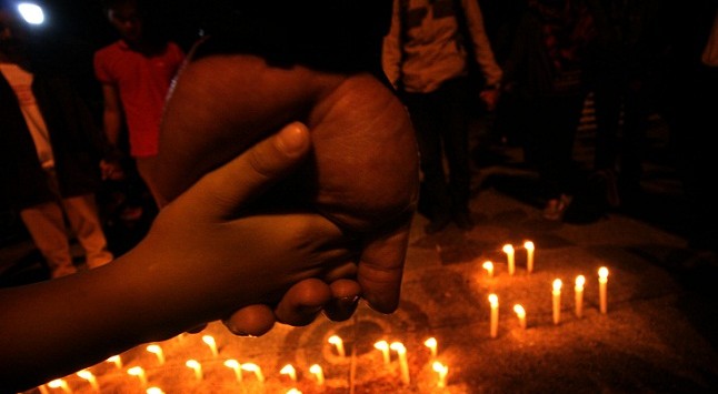 Puluhan massa dari berbagai aliansi dan lembaga sosial masyarakat tersebut menyalakan lilin sambil berdoa di Taman Cikapayang, Jalan Ir H Juanda, Jumat ( 15/1/2016) malam. (FOTO: RAMDHANI)