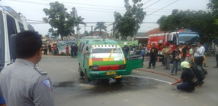 Petugas Damkar memadamkan api yang membakar angkot, karena tertimpa kabel listrik