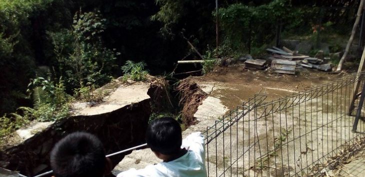 Dua orang bocah mengamati retakan tanah akibat longsor melanda mengancam desanya. (habibie)