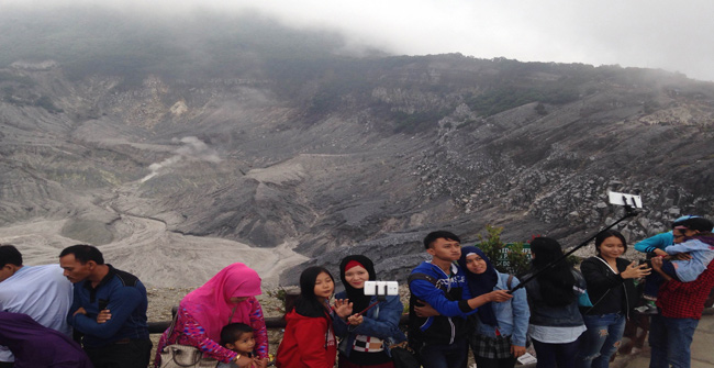 Para pengunjung menikmati liburan lebaran sambil melakukan selfie dengan background kawah Tangkuban Parahu.