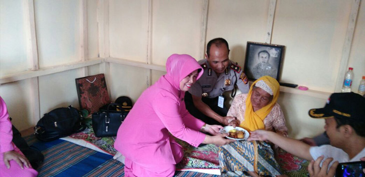  Nenek Ocih menerima potongan tumpeng di rumahnya yang baru beres renovasi. 