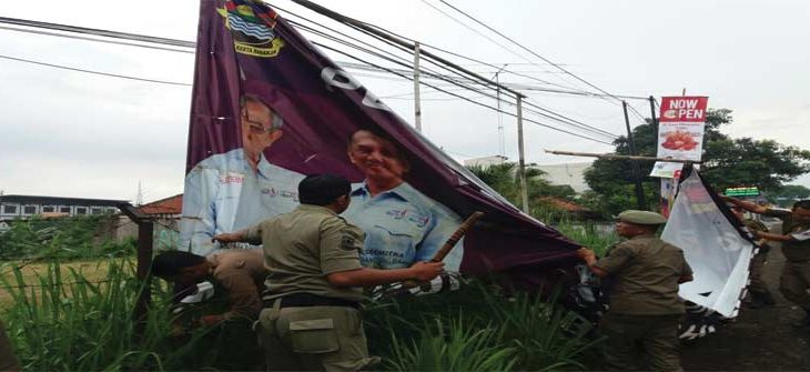 TERTIBKAN: Petugas Satpol PP Kabupaten Bandung Barat (KBB) menertibkan sejumlah spanduk yang sudah rusak dan tidak sesuai aturan.