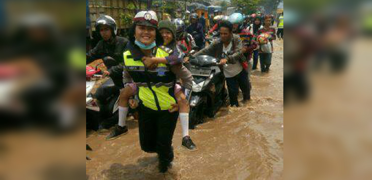 Polwan Polres Bandung menggendong anak yang terjebak banjir