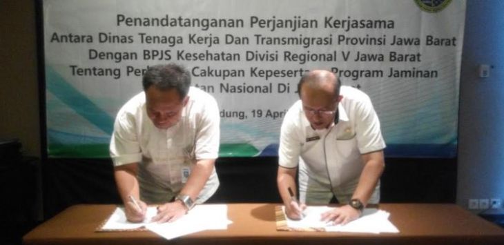 Kepala Divisi Regional V BPJS Kesehatan Jabar, Mohammad Edison (kiri) bersama Kadisnakertrans Jabar, Ferry Sofwan Arif (kanan) menandatangi kerjasama program perluasan kepersertaan JKN-KIS, Rabu (19/4). Foto: Asep Rahmat 