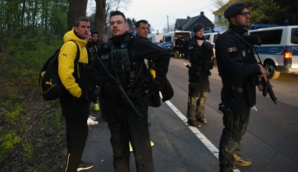 Pemain Borussia Dortmund berdiri dengan polisi bersenjata lengkap (Foto: AFP)