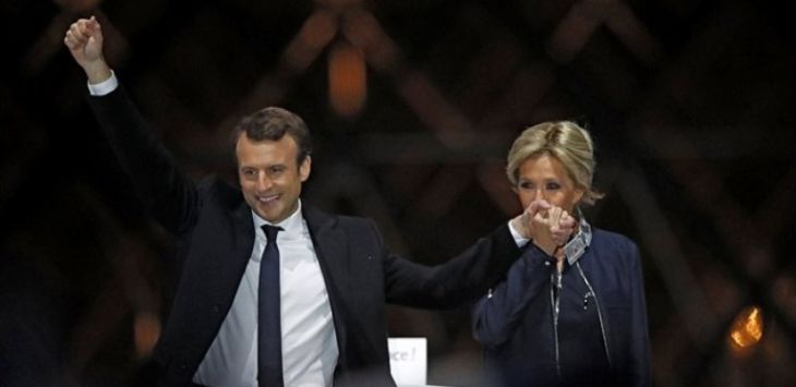 Emmanuel Macron bersama istrinya Brigitte menyapa pendukungnya setelah hasil exit polls keluar. (Christian Hartmann/Reuters)