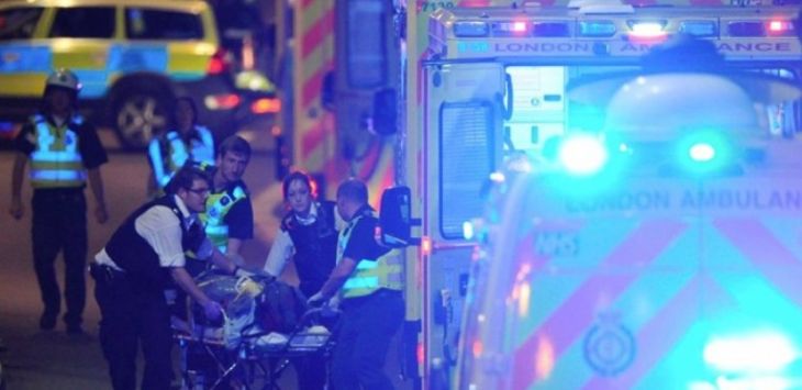 Polisi dan petugas kesehatan sedang membawa salah satu korban dari serangan di London Bridge menuju ambulan. (AFP)