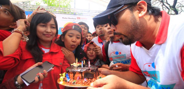 General Manager Radar Bandung Group, Tegar Bagja Anugrah (kiri), meniup lilin dari kue ulang tahun.