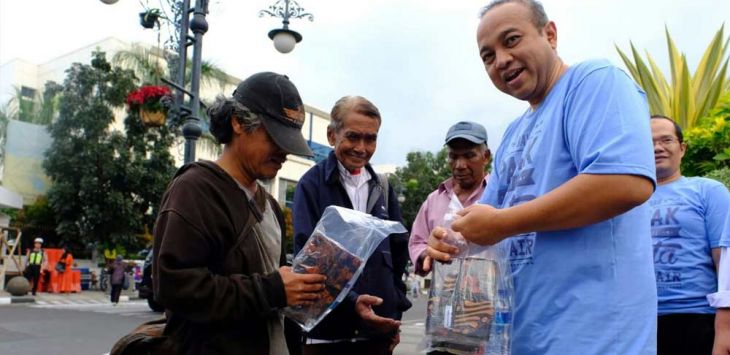 Kepala Kanwil DJP Jabar I Yoyok Satiotomo (kanan) saat membagikan takjil kepada warga yang lewat Jalan Asia Afrika, Bandung.