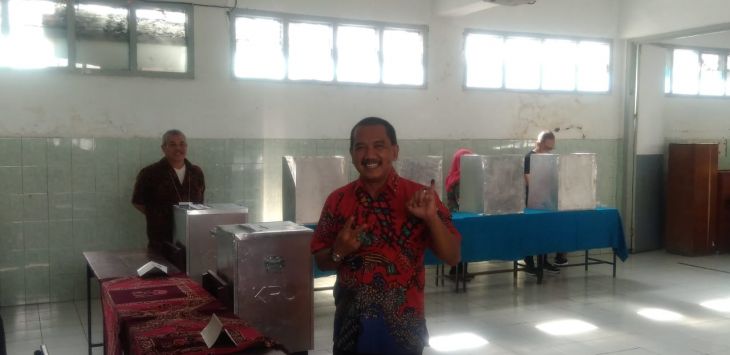 Aries Supriatna mengenakan batik lengan pendek berwarna merah saat mencoblos di TPS 01 Melania Kelurahan Cihaurgeulis, Kecamatan Cibeunying Kaler, Kota Bandung, Rabu (27/6).