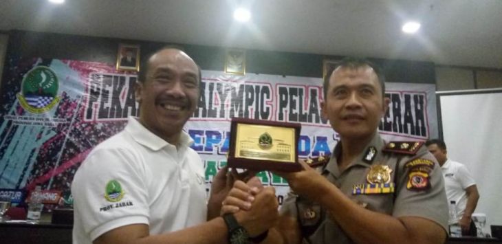 Kabid Pembudayaan Olahraga Dispora Jabar, Dadang Ronda menyerahkan cinderamata untuk Kapolsek Cidendo sebagai bentuk penghargaan Kadispora Jabar atas kerjasama dalam pelaksanaan Peparpeda 2018 di Pajajaran. Foto:Istimewa