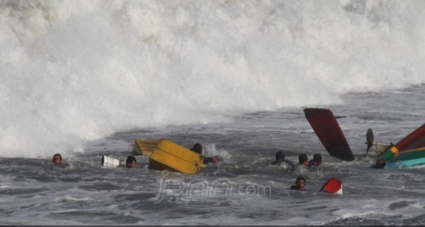 Kapal nelayan saat dikandaskan ombak di pantai Pancer Puger Kabupaten Jember Jatim, Kamis (19/7/2018). Foto: jumai/jawa pos/radar jember 