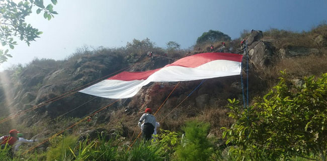 Perwakilan pemuda di wilayah Lembang saat mengibarkan bendera raksasa di Gunung Batu Pagerwangi, Kecamatan Lembang, KBB, Selasa (14/8/2018).