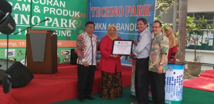 Kepsek SMKN 11 Bandung, Ane Sukmawati secara simbolis penandatangan kerjasama dengan pihak industri saat launcing program dan produk starup di SMKN 11 Bandung Sabtu, (15/9/2018).Foto:Ipan Sopian/Radar Bandung/Pojokbandung