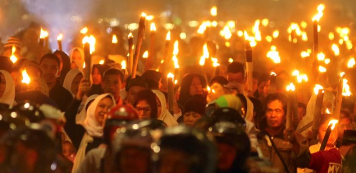 Sejumlah warga mengikuti pawai obor saat melintas di Jalan Asia-Afrika, Kota Bandung, Senin (10/9/2018) malam. 