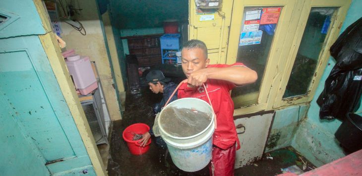 Warga membersihkan air dan lumpur saat banjir menerjang kawasan Pagarsih, Kota Bandung, Senin (26/11).
(Riana)