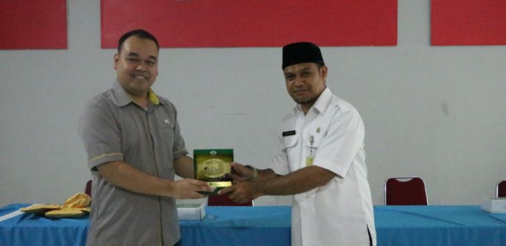Pejabat Pengganti Sementara Kepala Kantor BPJS Ketenagakerjaan Bandung Suci, Bimo Prasetiyo (kiri), menyerahkan plakat penghargaan kepada Sekcam Kecamatan Cibeunying Kaler, Mahyudin, sebagai bentuk apresiasi karena sudah mendaftarkan seluruh RT dan RW diwilayahnya, Selasa (4/12).
