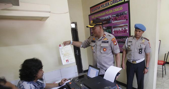 Kapolsek Ciracas Kompol Agus Widartono (topi cokelat) memantau pengurusan SKCK di Kantor Polsek Ciracas, Jakarta, Jumat (14/12). Pasca kerusakan dan pembakaran Polsek Ciracas mulai kembali normal dan melayani masyarakat untuk pengurusan berkas.