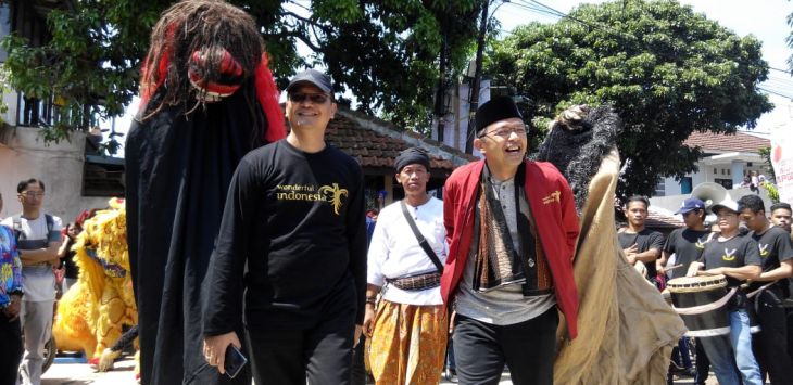 Kepala Bidang Pengembangan dan Pemasaran Area I (Jawa), Kemenpar Republik Indonesia, Wawan Gunawan (kiri) bersama Ketua Nasional Masyarakat Sadar Wisata, Maman Imanulhaq Faqih (kanan) disambut seni reak saat acara Festival Pesona Bauran Cap Golak 2019 di Kampung Jati, Kelurahan Pasirbiru, Kecamatan Cibiru, Kota Bandung, Sabtu (23/2).