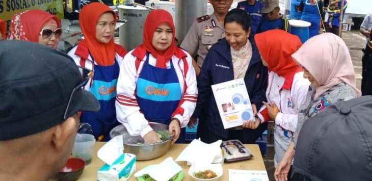 Menteri BUMN Rini M Soemarno, Direktur Utama Pertamina Nicke Widyawati dan Ibu-ibu pegiat Omaba memasak dan menyiapkan makanan anak di salah satu tenda pengungsi di Baleendah, Kabupaten Bandung yang merupakan daerah terdampak banjir luapan Sungai Citarum.