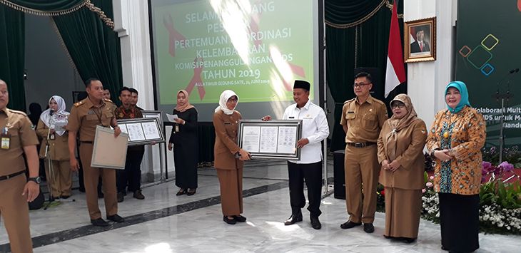 SIMBOLIS : Wakil Gubernur Jawa Barat Uu Ruzhanul Ulum (kanan), menyerahkan hasil komitmen kesepakan kepada Kadinkes Kota Cimahi drg Pratiwi (kanan), di Aula Timur Gedung Sate, Jalan Diponegoro, Senin (24/6/2019).
( Foto : GATOT POEDJI UTOMO/RADAR BANDUNG )
