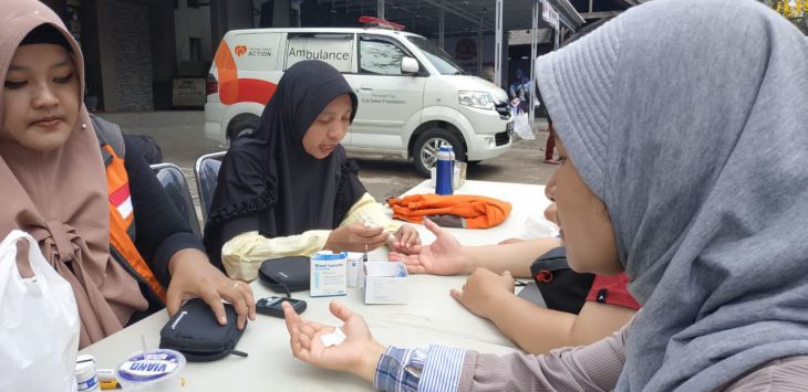 PERIKSA : Petugas kesehatan Rumah Zakat memberikan pelayanan cek kesehatan gratis, di Car Free Day (CFD) Dago, Jalan Ir. H. Juanda, Bandung, Minggu (15/12).(foto : GATOT POEDJI UTOMO/RADAR BANDUNG) 