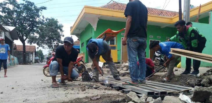 Rekan-rekan ojek membongkar jembatan besi penghubung Kampung Cidadap.