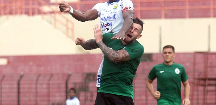 Pemain Persib Bandung Victor Igbonefo (atas) berduel dengan pemain PSS Sleman Aaron Evans dalam laga uji coba di Stadion Sultan Agung, Bantul, DIJ,Senin (17/2/2020). Persib Bandung menang atas PSS Sleman dengan skor 2-0. 