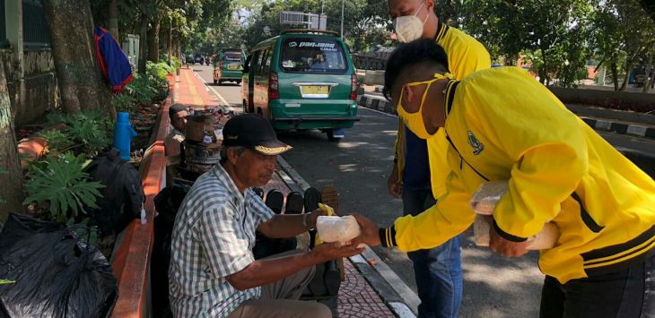 BAKTI SOSIAL : Kader Golkar Kota Cimahi membagikan kebutuhan pokok kepada warga di Jalan Encep Kartawirya