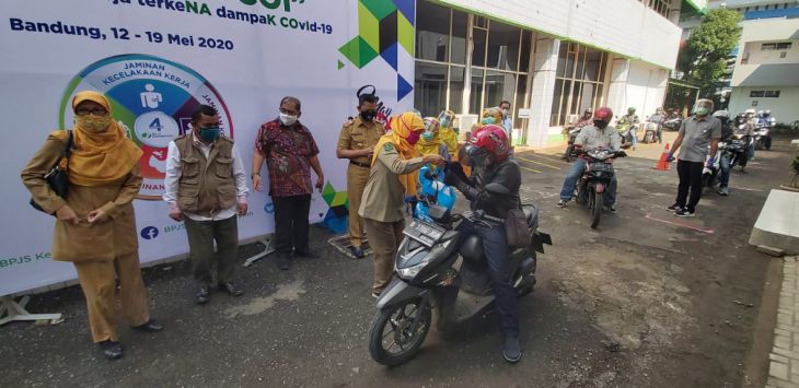 DRIVE THRU: BPJAMSOSTEK Kanwil Jabar bagikan bantuan sembako dengan menerapkan protokol kesehatan (physical distancing) dengan cara drive thru.