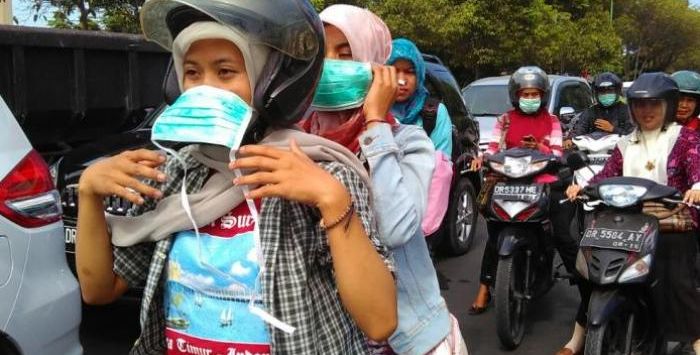 PAKAI MASKER: Pengendara sepeda motor saat memakai masker sebagai upaya pencegahan penyebaran virus Covid-19.