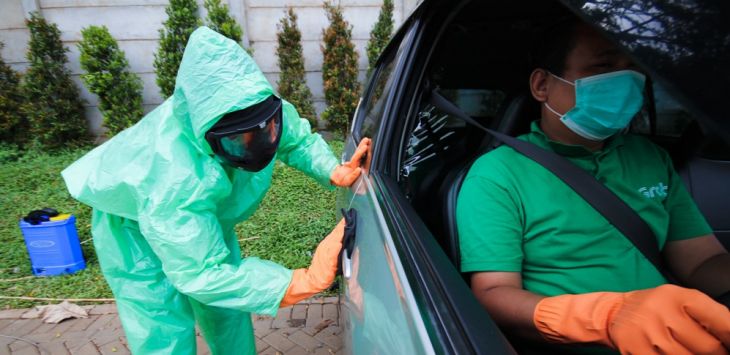 BERSIH: Proses pembersihan dan penyemprotan disinfektan terhadap unit layanan GrabCar Protec.