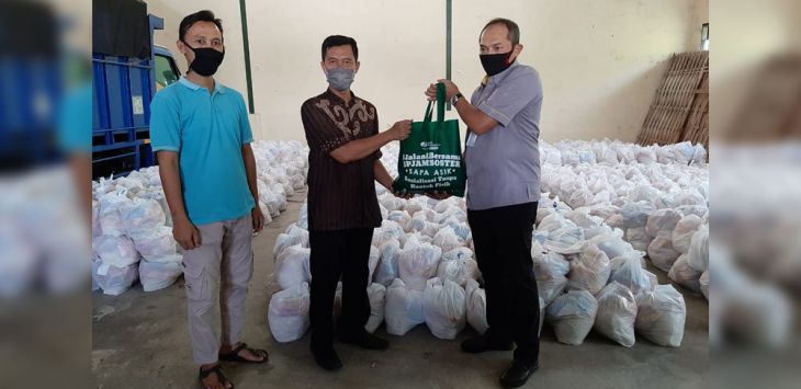 BANTUAN: Seorang warga menerima bantuan paket sembako dari 
BPJAMSOSTEK, kemarin.
(Foto : IST)