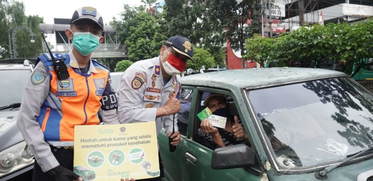 APRESIASI: Grab dab Dishub Kota Bandung berikan apresiasi pada pengguna jalan yang menerapkan protokol kesehatan dengan membagikan voucher belanja, hand sanitizer, dan masker. (foto : ist)