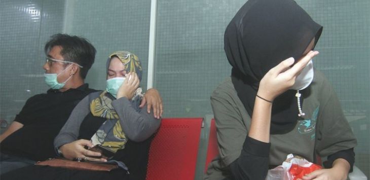 MENUNGGU KEPASTIAN: Keluarga penumpang Sriwijaya Air menunggu kabar di Bandara Supadio, Pontianak. (LOUS ANDERSON/AFP)