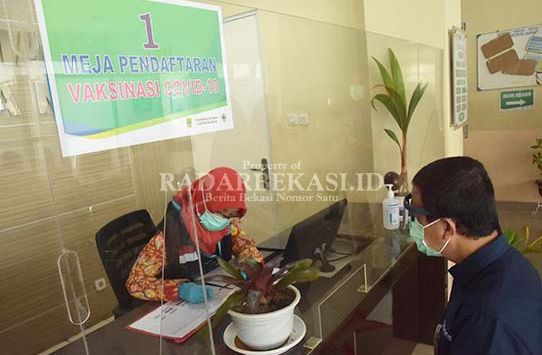 LAYANI VAKSINASI: Seorang tenaga kesehatan (nakes) sedang melayani pendaftaran vaksinasi di Puskesmas Cikarang, Kabupaten Bekasi, Senin lalu (1/2/2021) (foto: ARIESANT/RADAR BEKASI)