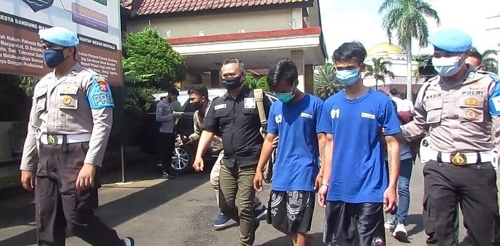 TERSANGKA : Dua tersangka pemukulan anak di bawah umur diperlihatkan saat ekspos di Mapolresta Bandung, Soreang, Senin (22/2/2021) (foto : Fikriya Zulfah/Radar Bandung)