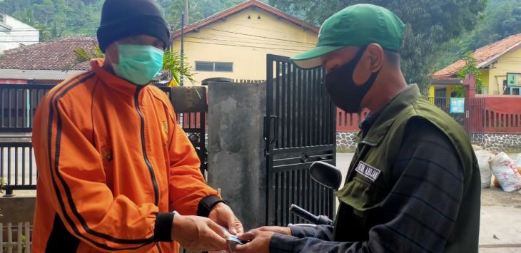 BANTUAN : Ketua Jabar Bergerak KBB Bidang Sosial, Rozacx Abdul (kanan) menyerahkan bantuan uang tunai kepada Japar, Senin (22/2/2021) (foto : IST)