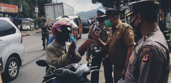 HADIAH : Seorang pengguna sepeda motor taat prokes mendapat hadiah
(FOTO : TOHA/RADAR SUMEDANG }