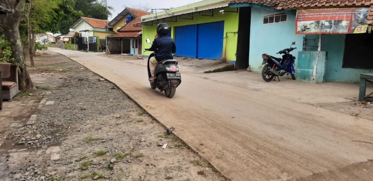 MELINTAS : Sebuah kendaraan melintasi jalan beton yang ada di Desa Cilampeni Kabupaten Bandung. (foto: FIKRIYA ZULFAH/RADAR BANDUNG)