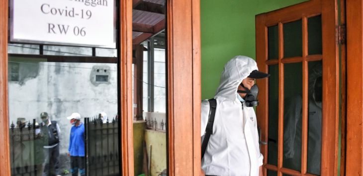 WASPADA: Petugas menyemprotkan cairan disifektan di rumah warga saat operasi gabungan patroli pengawasan dan pengakan disiplin protokol kesehatan Covid-19 (foto : TAOFIK ACHMAD HIDAYAT/RADAR BANDUNG)