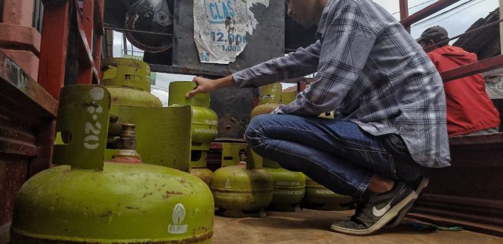 MERAPIHKAN : Seorang pria tengah merapihkan LPG 3 KG di sebuah mobil bak. FOTO: TAOFIK ACHMAD HIDAYAT