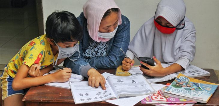 DIDAMPINGI: Siswa didampingi orang tua saat melaksanakan Pembelajaran Jarak Jauh (PJJ) di Tamansari Atas, Kota Bandung, Selasa (24/11) (foto: AOFIK ACHMAD HIDAYAT/RADAR BANDUNG)