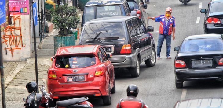 JURU PARKIR: Petugas parkir membantu merapihkan kendaraan yang terparkir di Jalan Amir Machmud, Kota Cimahi, beberapa waktu lalu. (foto: TAOFIK ACHMAD HIDAYAT/RADAR BANDUNG)