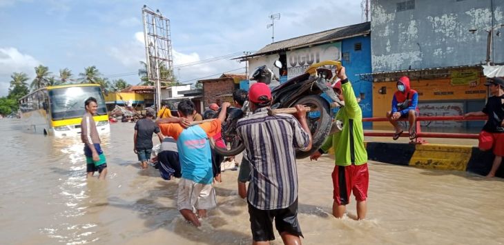 EVAKUASI : Warga mengavakuasi sepeda motor saat bencana Banjir Subang. Akibat banjir  ribuan warga di wilayah Subang utara mengungsi. (foto : M.ANWAR/RADAR BANDUNG)