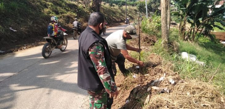 SANKSI : Seorang warga saat menjalani sanksi menanam pohon karena menebang
pohon secara sembarangan. (Fikriya Zulfah/Radar Bandung)