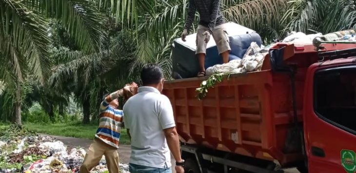 Kades Kumpay, Asep Pulloh terjun langsung untuk mengangkut sampah di area perkebunan sawit desa Kumpay, Rabu (1/12). (FOTO: M.ANWAR/RADAR BANDUNG)