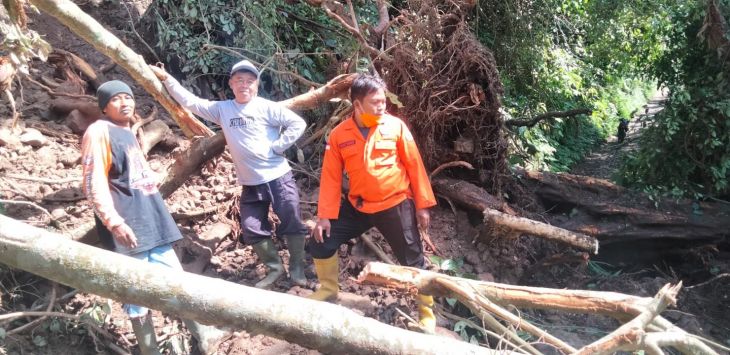 Petugas BPBD bersama warga membersihkan material longsor yang menutup badan jalan Cupunagara, Subang, Kamis (2/12). (FOTO: M.ANWAR/RADAR BANDUNG)